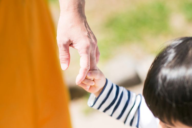 mother holding a small childs hand