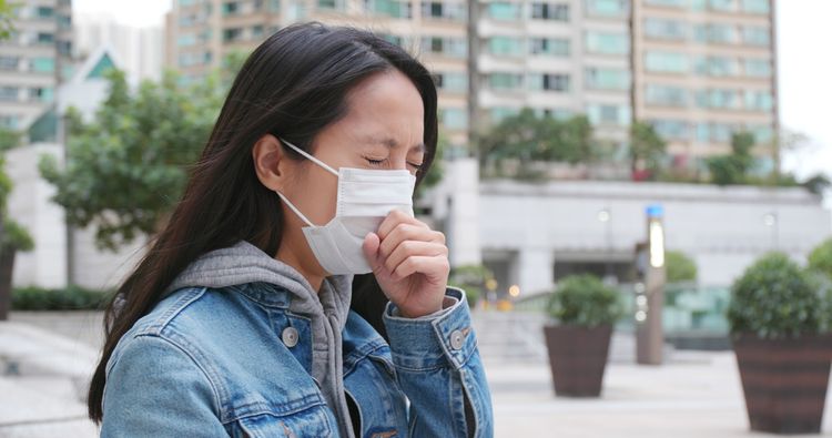 sneezing woman in mask