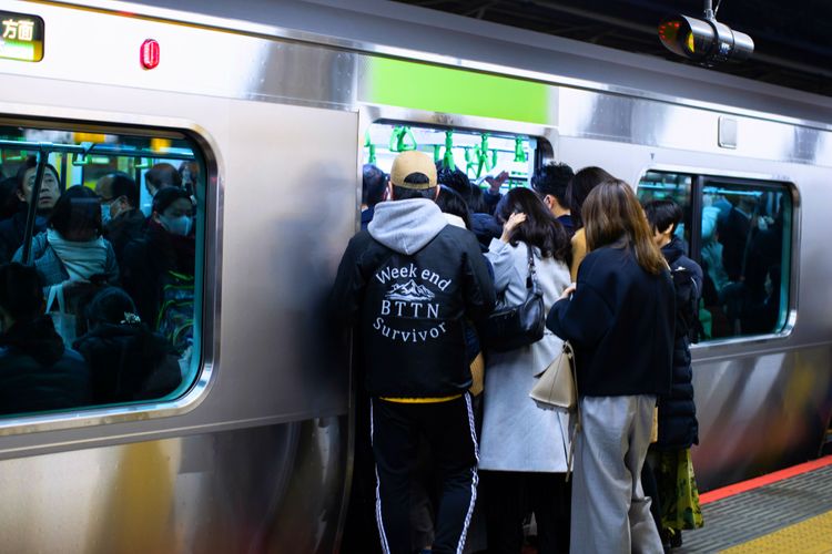 people crowding onto the yamanote train