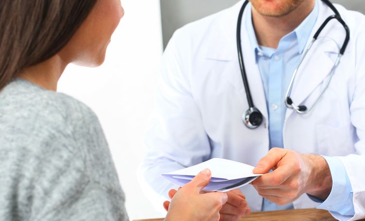 doctor passing note to patient