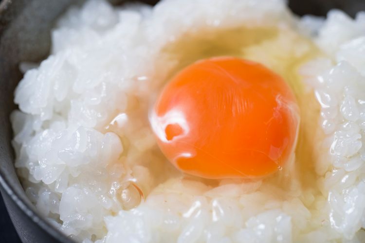 a raw egg on top of rice