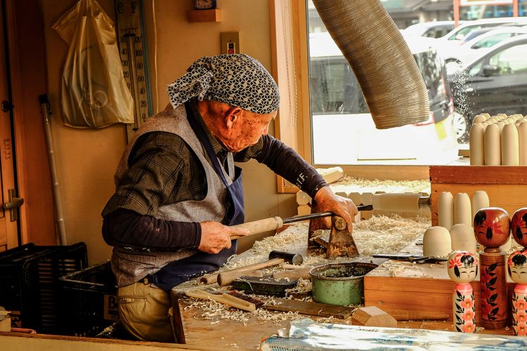 Japanese artisan making a kokeshi doll