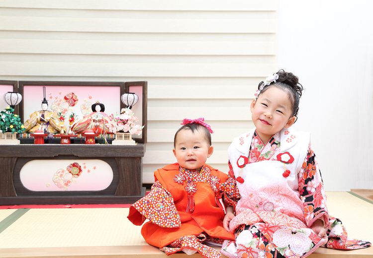 young girls in front of hina dolls