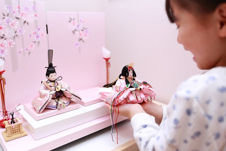 young girl playing with mebina doll