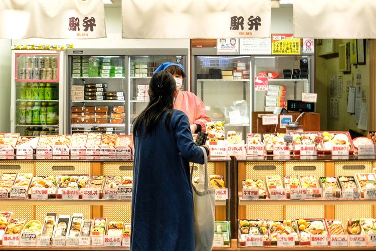 woman standing in front of bento shop